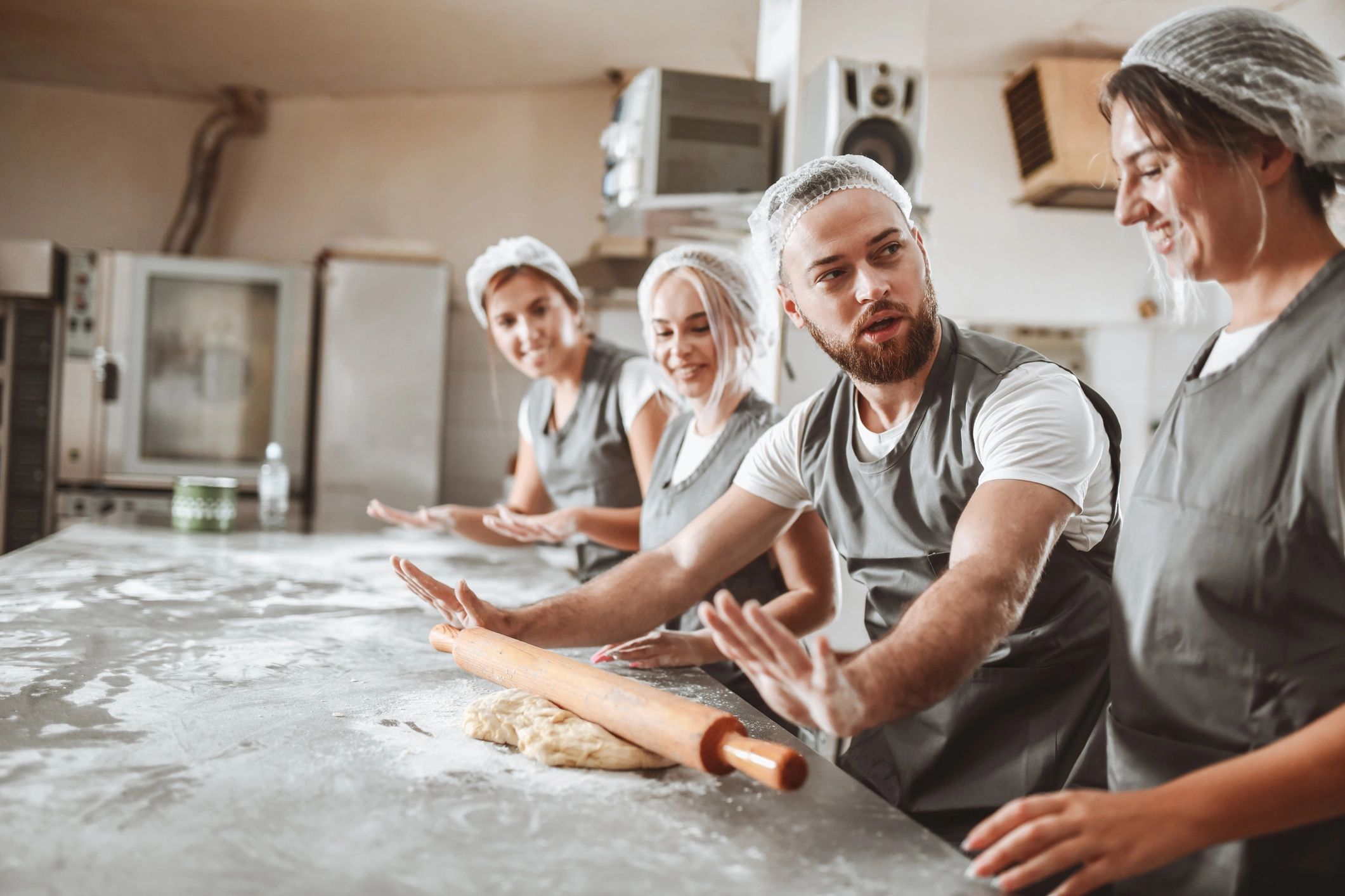 Baker demonstrating technique with a rolling pin