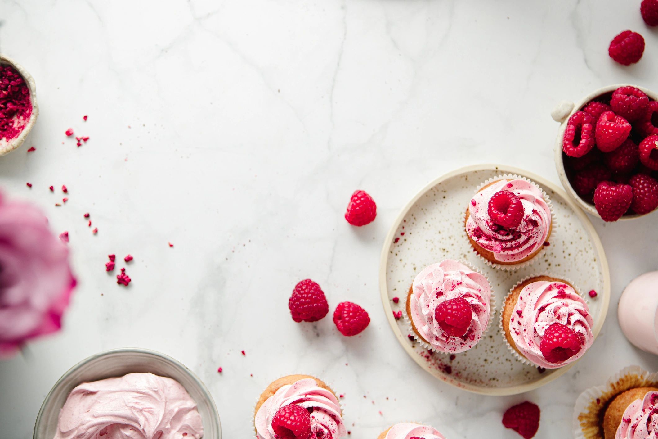 Pink frosted cupcakes on a counter