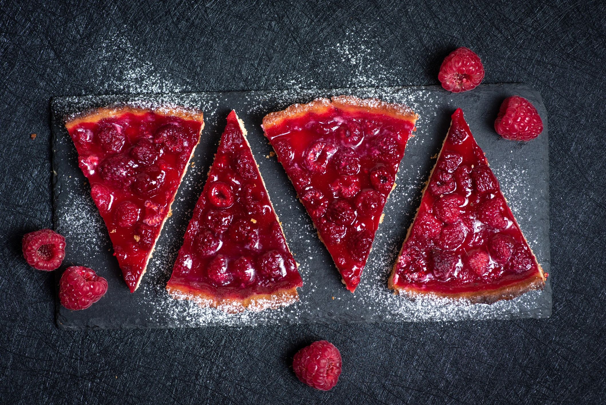 Raspberry tart slices topped with fresh raspberries