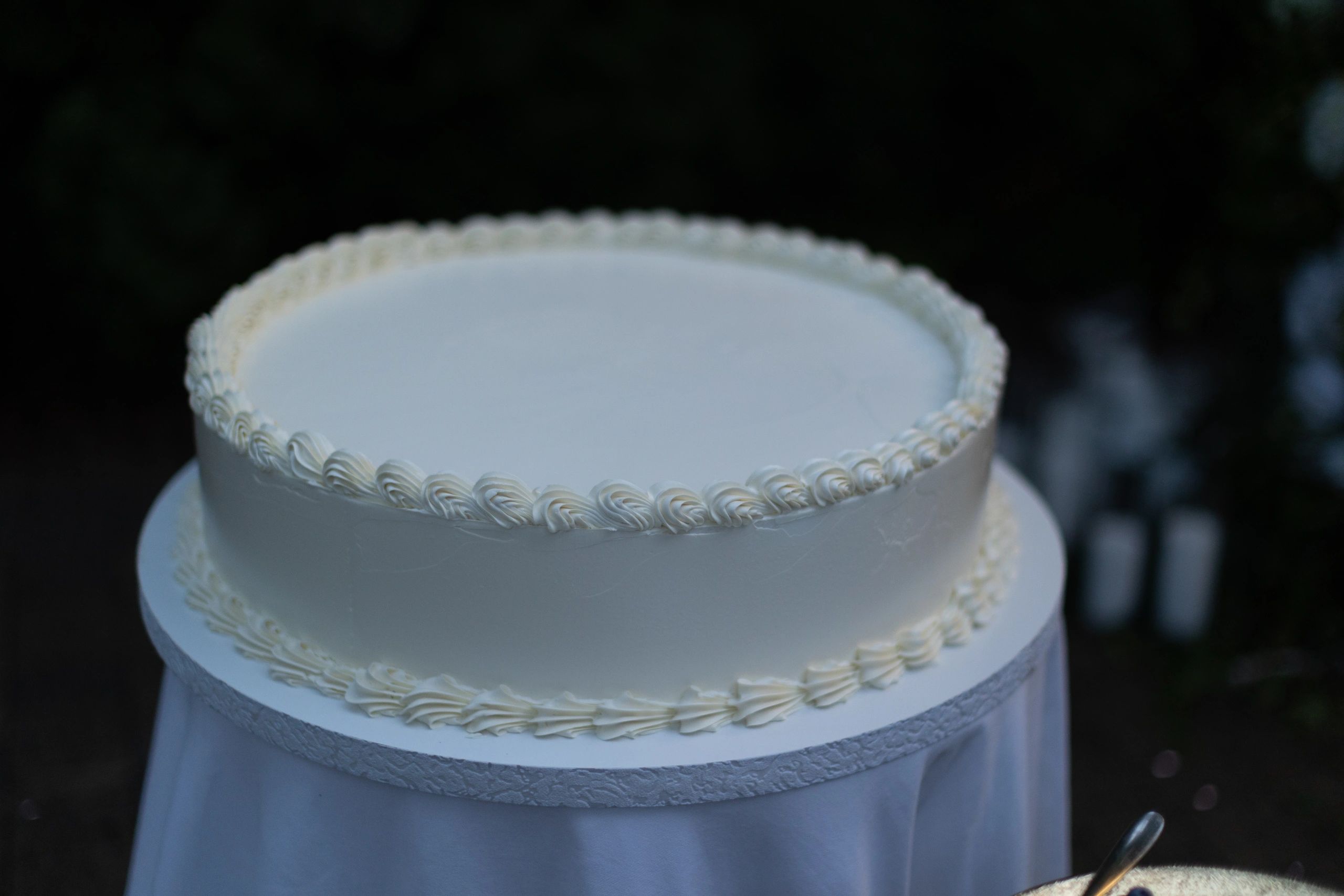 White tiered wedding cake with buttercream piping